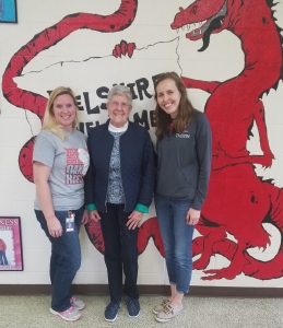 Delshire Snack Sack team members in front of the school dragon mural